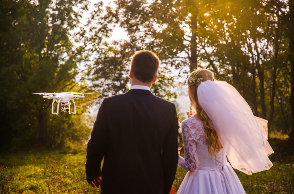 Bride-and-groom-look-at-drone-taking-video